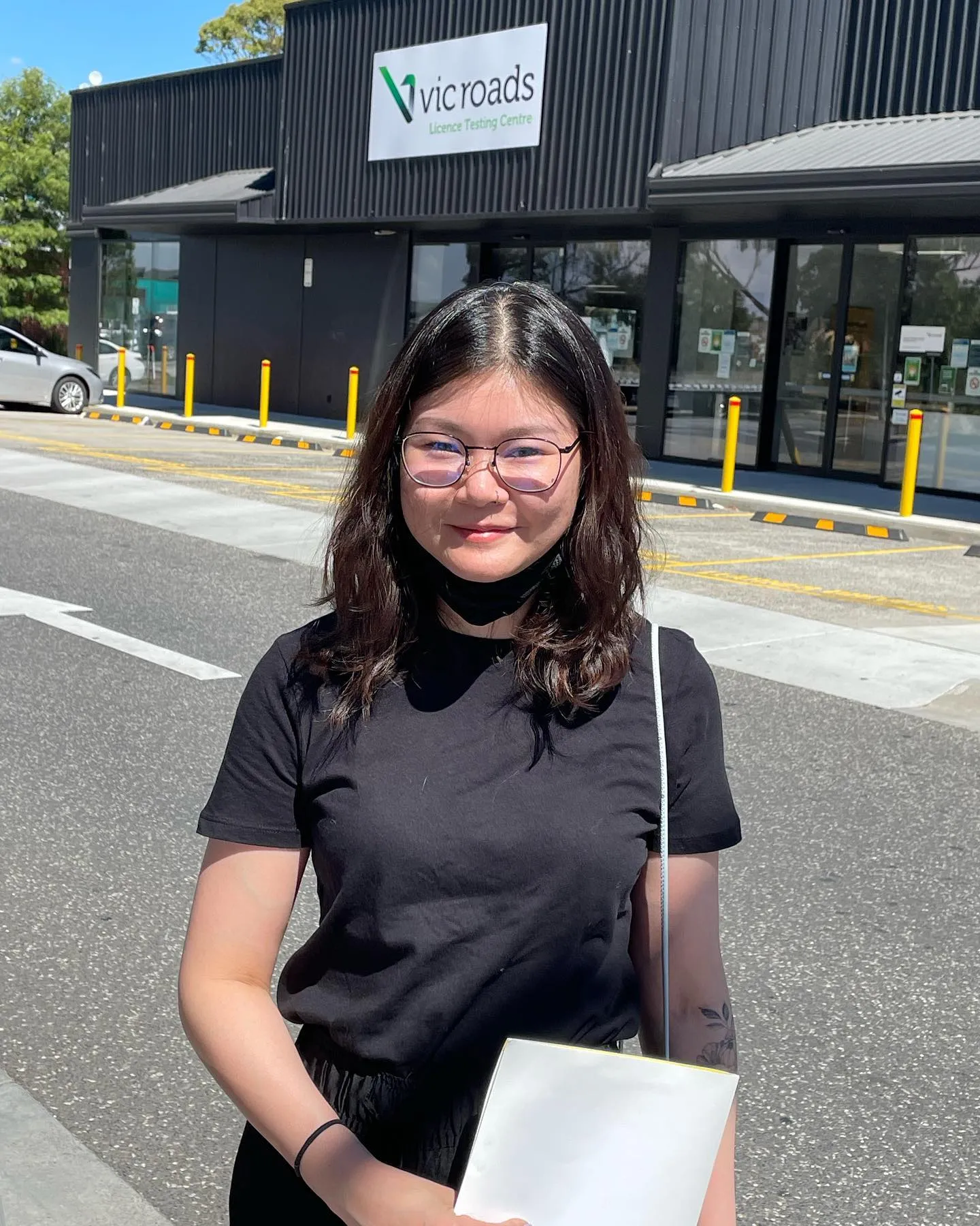 Smiling young person with glasses outside VicRoads Licence Testing Centre.