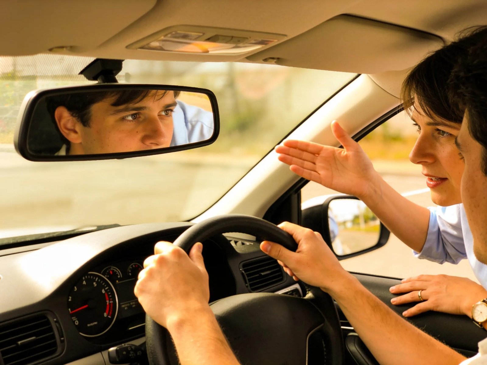 Learner driver practicing mirror checks during driving lessons to enhance essential driving skills.